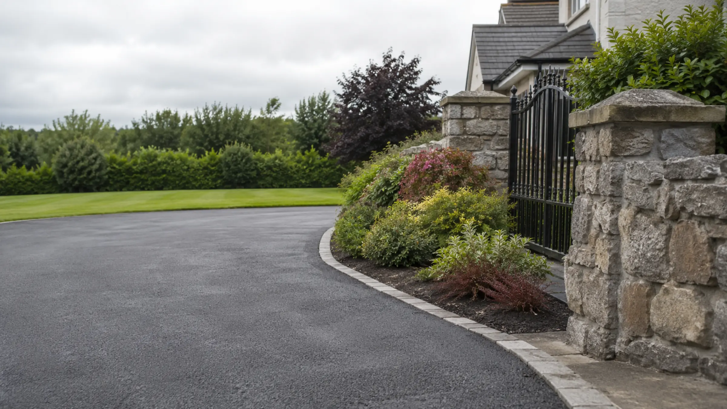 A sweeping gravel driveway leading to a home in the Irish countryside